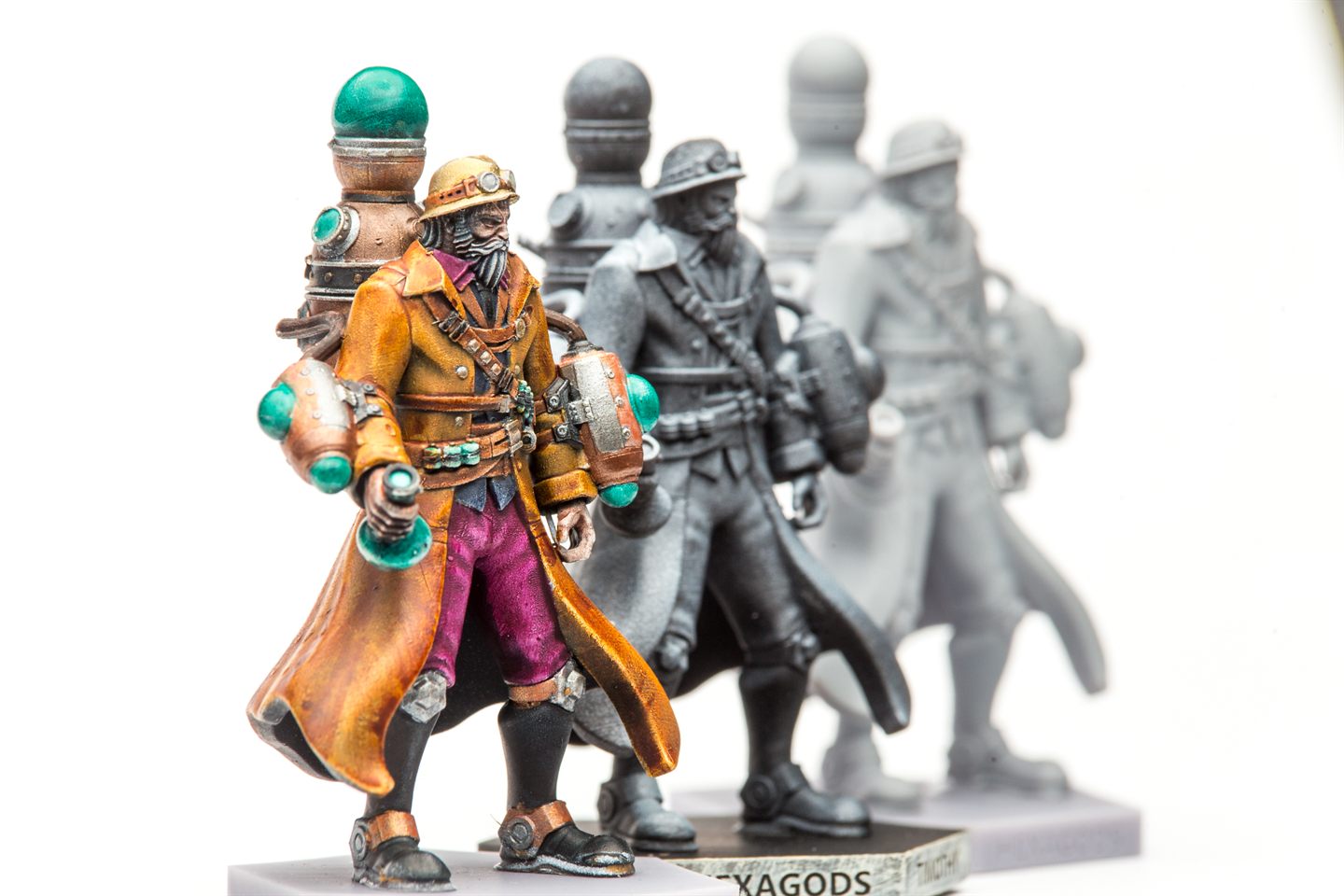 Painted Hexagods miniatures on a workbench